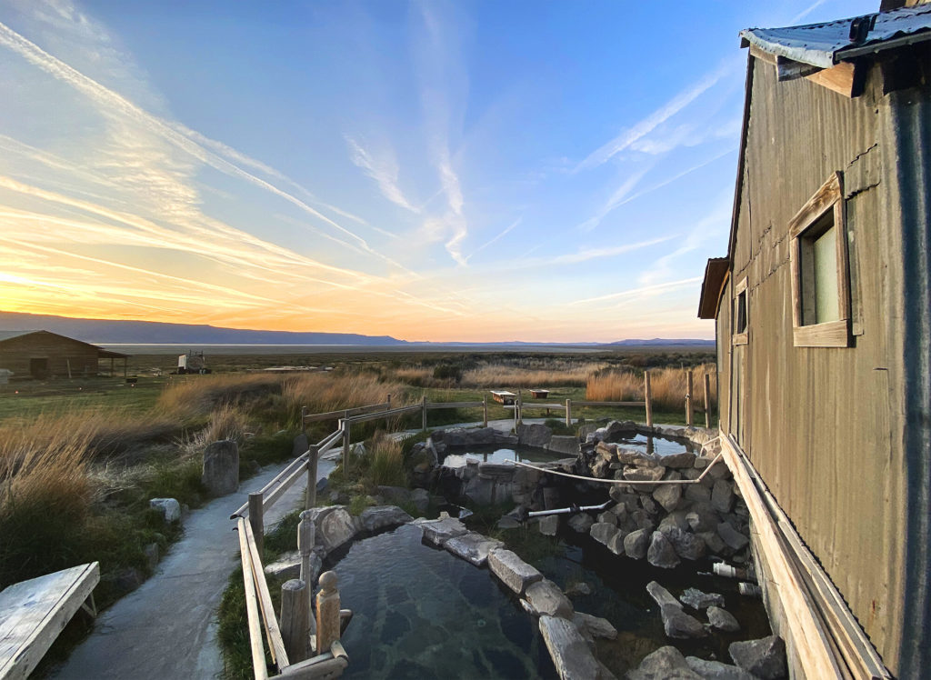 Sunset over the outdoor rock-walled soaking tubs at Summer Lake Hot Springs in Lake County, Oregon