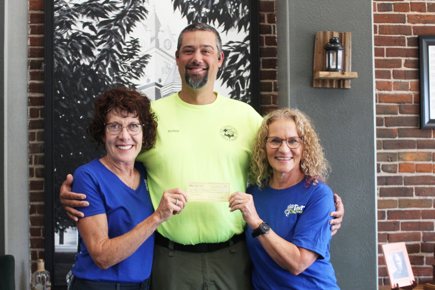 Tour de Outback co-chairs Marie Murphy Tucker and Donna Barry Russell with Lake County Search and Rescue Commander Chris Bishop at the 2024 proceeds donation.