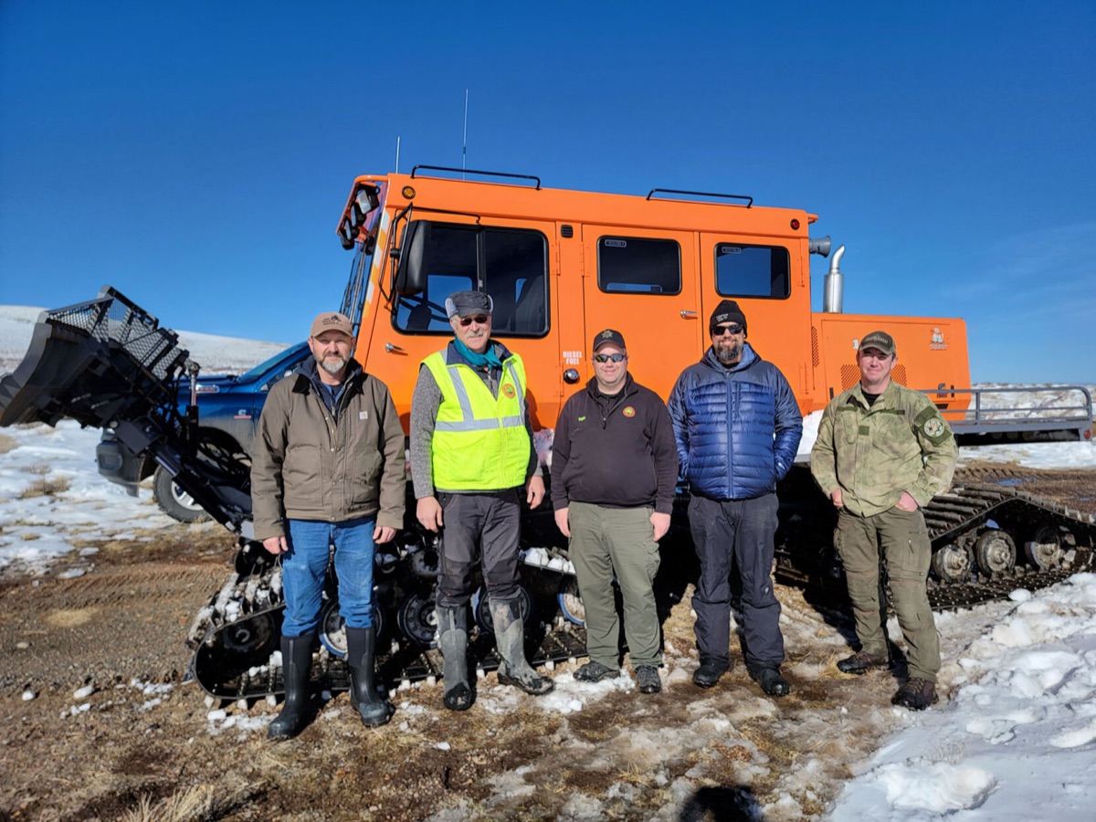 Lake County Sheriff's deputy, Search and Rescue volunteers and BLM staff with a snowcat after repairing the Warner Peak radio repeater.
